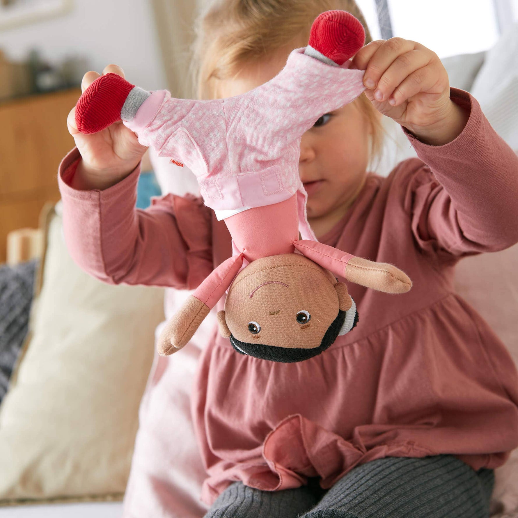 Snug Up Rumbi soft doll sitting by HABA USA